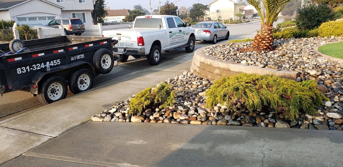 Gallegos work truck beside a finished decorative-rock front yard