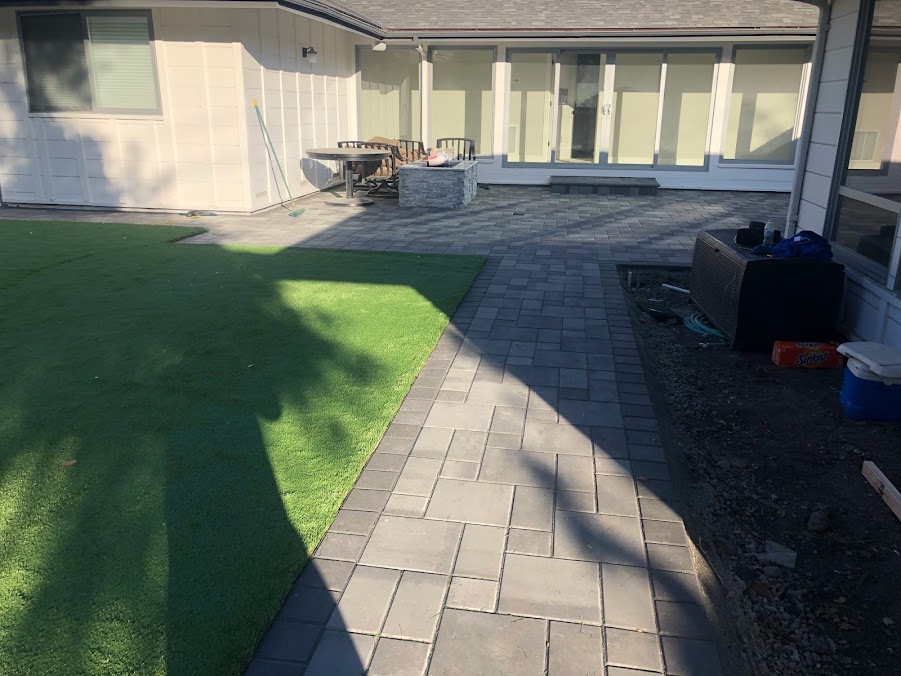 Backyard landscape with artificial turf and paver patio